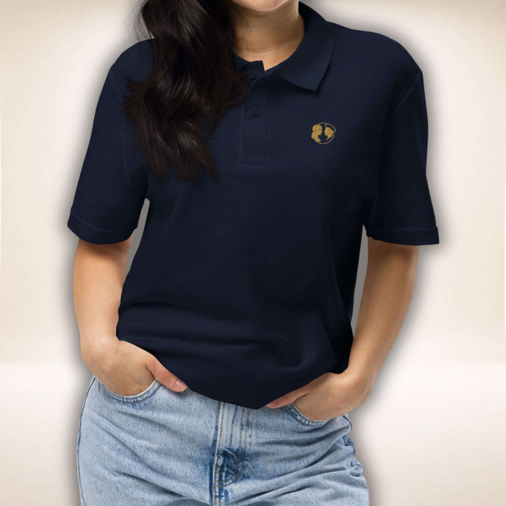 Navyfarbenes Belgravia Polo mit goldenem Doppelprofil-Logo, von einer Frau getragen