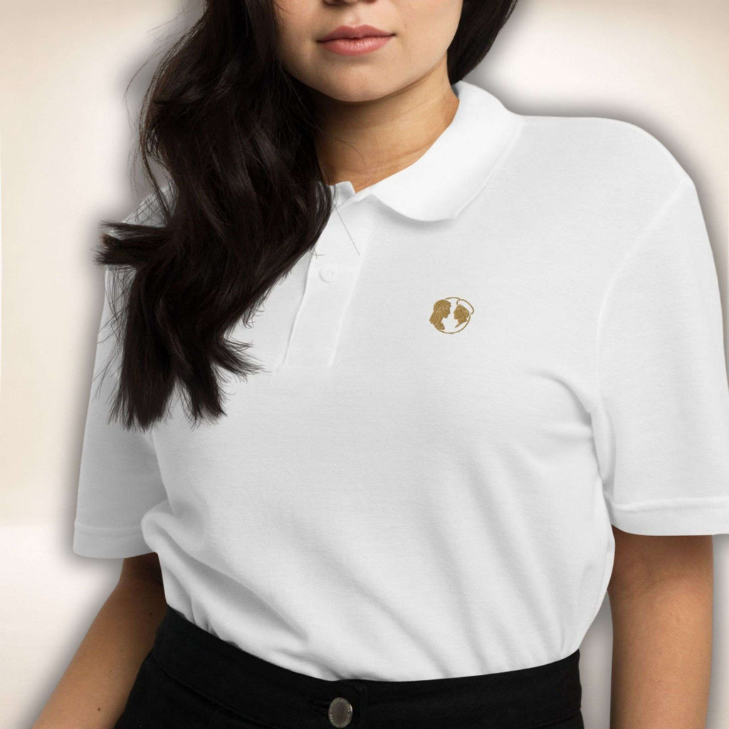 Weißes Belgravia Polo mit goldenem Doppelprofil-Logo, von einer Frau getragen